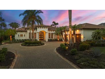 Elegant Mediterranean-style home featuring a circular driveway, lush landscaping, and a grand entrance at 8312 Catamaran Cir, Lakewood Ranch, FL 34202