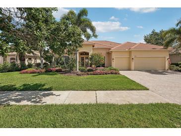Charming home features a tile roof, a three-car garage, and lush landscaping at 1251 Tuscany Blvd, Venice, FL 34292