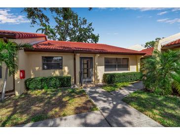 Charming single-story villa with a red tile roof, neat landscaping, and inviting walkway, creating great curb appeal at 1409 57Th W St # 1409, Bradenton, FL 34209