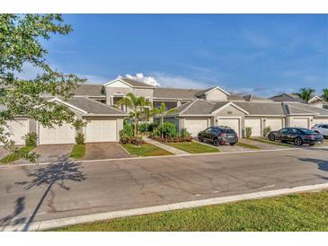 Townhome exterior featuring attached garages, well-maintained landscaping, and a paved driveway at 14257 Heritage Landing Blvd # 1122, Punta Gorda, FL 33955