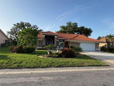 Charming home featuring a red tile roof and well-maintained landscaping, offering classic curb appeal at 387 Eden Dr Dr, Englewood, FL 34223