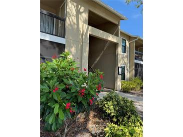 Inviting condominium exterior featuring a landscaped entrance, balconies, and a well-maintained facade at 4037 Crockers Lake Blvd # 24, Sarasota, FL 34238