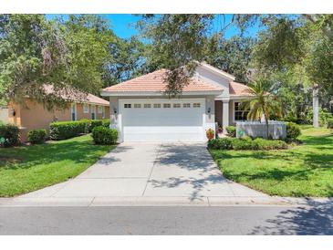 Charming single-story home with a tile roof, a two-car garage, and a well-manicured front yard at 4121 Reflections Pkwy, Sarasota, FL 34233