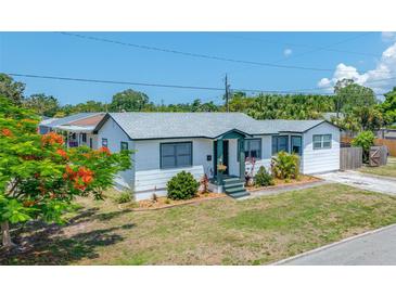 Charming single-story home featuring white siding, green trim, and well-maintained front yard landscaping at 440 42Nd N St, St Petersburg, FL 33713