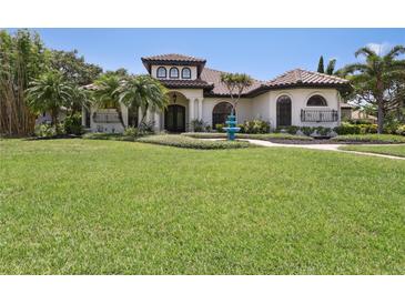 Beautiful Mediterranean-style home featuring lush landscaping, a manicured lawn, and a charming blue fountain at 4696 Del Sol Blvd, Sarasota, FL 34243