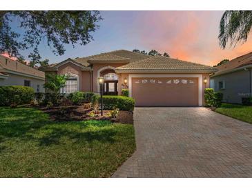 Beautiful single-story home featuring a well-manicured lawn, tile roof, and paved driveway leading to the two-car garage at 5074 Flagstone Dr, Sarasota, FL 34238