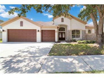Charming single-story home with a well-manicured lawn and a three-car garage, set under a beautiful blue sky at 5240 Silver Charm Ter, Wesley Chapel, FL 33544