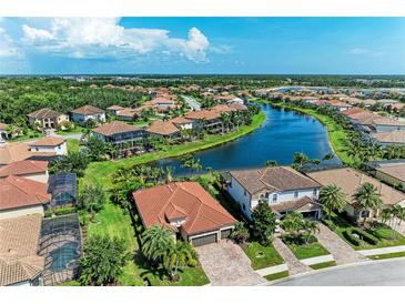 Beautiful aerial view of houses surrounding a long lake, and tropical landscaping in a wonderful neighborhood at 5511 Foxfire Run, Lakewood Ranch, FL 34211