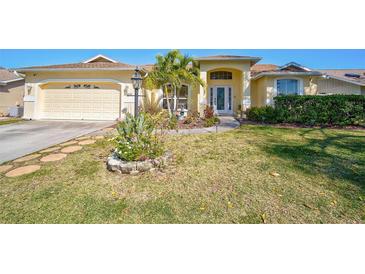 Charming single-story home featuring a well-manicured lawn, lovely landscaping, and an attached two-car garage at 5565 Sweetwater Oak Dr, Sarasota, FL 34232