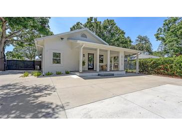 Charming exterior of a well-maintained single-story home with a welcoming front porch and ample parking space at 815 N East Ave, Sarasota, FL 34237