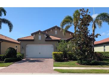 Charming single-story home with a brick driveway, two-car garage, and lush landscaping at 119 Maraviya Blvd, Nokomis, FL 34275