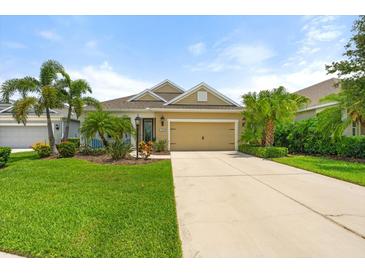 Charming single-story home with a well-manicured lawn, mature landscaping, and a two-car garage at 12327 Halfmoon Lake Ter, Bradenton, FL 34211