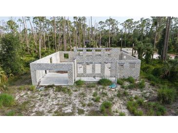 Construction of a cinder block house in wooded area shows foundation, block walls, and garage support at 17461 Dudley Ave, Port Charlotte, FL 33954