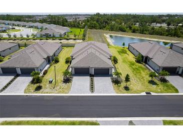 An aerial view of the neighborhood showcasing well-manicured lawns, a pond, and charming single-Gathering homes at 2016 Bonito Way, Port Charlotte, FL 33953