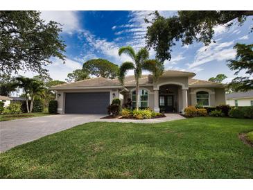 Charming single-story home featuring lush landscaping, a two-car garage, and a welcoming front entrance at 2149 Muskogee Trl, Nokomis, FL 34275