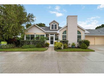 Charming home featuring arched windows, a well-manicured lawn, and a two-car garage at 4629 Whirlaway Dr # B, Sarasota, FL 34233