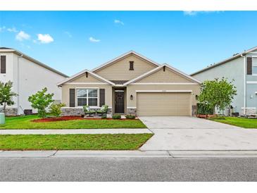 Charming single-Gathering home featuring a well-manicured lawn, neutral exterior, and a two-car garage at 5659 Woodland Sage Dr, Sarasota, FL 34238