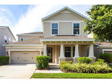 Charming two-story home featuring a covered front porch, well-maintained landscaping, and an attached two-car garage at 7113 Park Tree Dr, Tampa, FL 33625