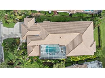 Aerial view of a home with a screened-in pool and well-manicured landscaping, surrounded by lush greenery at 7507 Ascot Ct, University Park, FL 34201