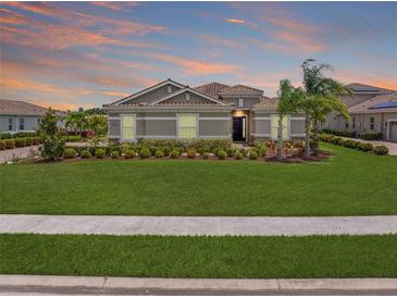 Charming home featuring a lush green lawn, well-manicured landscaping, and a tile roof at 7508 Ripetta St, Sarasota, FL 34240