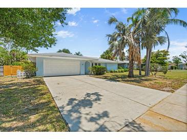 Charming single-story home with a well-manicured lawn, mature trees, and an attached two-car garage at 139 Adair Ave, Sarasota, FL 34243