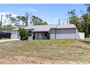 Charming single-story home featuring gray paint and a well-manicured front yard at 16834 Toledo Blade Blvd, Port Charlotte, FL 33954