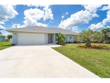 Charming single-story home with a well-manicured lawn, landscaping, and a two-car garage at 217 Mariner Ln, Rotonda West, FL 33947