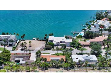 Charming waterfront property featuring a cozy home with a red tile roof, surrounded by lush tropical greenery at 223 Seagull Ln, Sarasota, FL 34236