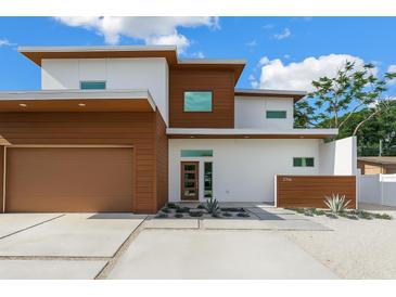 Contemporary home featuring clean lines, a flat roof, wood accents, and manicured landscaping at 2314 Floyd St, Sarasota, FL 34239