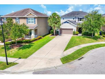 Charming two-story home boasts a well-manicured lawn and a long driveway leading to an attached two-car garage at 6125 Anise Dr, Sarasota, FL 34238