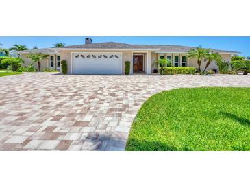 Charming home with brick driveway, manicured lawn, and lush tropical landscaping at 7913 19Th Avenue W Dr, Bradenton, FL 34209