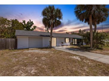 Charming single-story home with a one car garage and lush palm trees in the front yard at 112 E Marland Ct, Nokomis, FL 34275