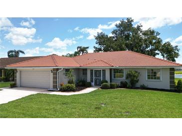 Charming single-story home featuring a beautiful tile roof, well-manicured lawn, and lush landscaping at 1654 Waxwing Ct, Venice, FL 34293