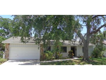 Charming single-story home with attached garage, mature trees, and well-maintained landscaping at 2475 Wood Oak Dr, Sarasota, FL 34232