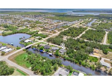 Expansive aerial view of canal-front home, showcasing waterfront access and lush surroundings at 3500 Liberty St, Port Charlotte, FL 33948