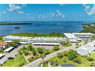 Stunning aerial view of waterfront condos, lush landscaping, and serene bay waters on a sunny day at 4736 Independence Dr # 4736, Bradenton, FL 34210