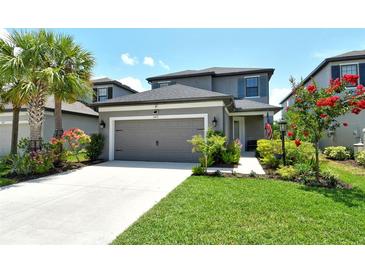 Charming two-story home with a well-manicured lawn, lovely landscaping, and an attached two-car garage at 5475 Summit Gln, Bradenton, FL 34203