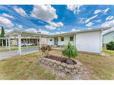 Charming single-story home featuring a covered carport and a well-maintained front yard at 5619 Bayshore Rd # 203, Palmetto, FL 34221