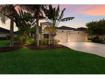 Beautifully landscaped single-Gathering home featuring a two-car garage and tropical landscaping at 12015 Forest Park Cir, Bradenton, FL 34211