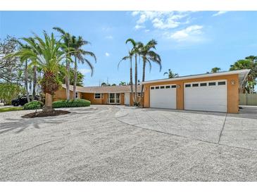 Stunning home featuring an oversized driveway, lush landscaping, and an attached two-car garage at 1203 Lyric Ln, Sarasota, FL 34242