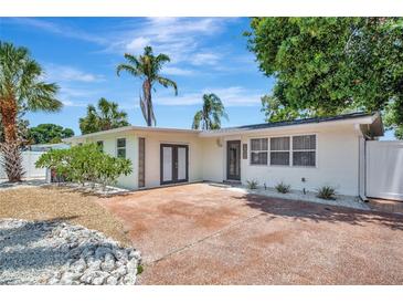 Charming single-story home featuring a well-manicured lawn, tropical landscaping, and an inviting front entry at 2363 Milford Cir, Sarasota, FL 34239