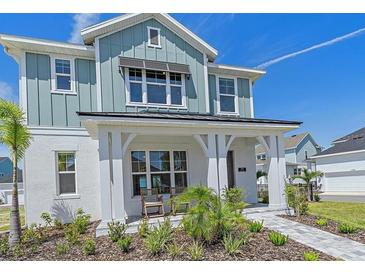 Charming two-story home with light blue siding, a welcoming front porch, and landscaped front yard at 7279 Kodiak Ln, Sarasota, FL 34240