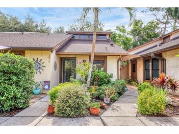 Charming home exterior with lush landscaping, potted plants, and a decorative sun at 7915 4Th W Ave # 7915, Bradenton, FL 34209