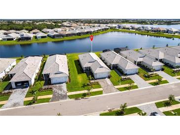 Beautiful aerial view of lakeside homes featuring manicured lawns and paver driveways at 8148 Sternway Rd, Sarasota, FL 34240