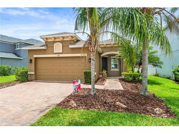 Inviting home featuring a two-car garage, mature landscaping, and a paver walkway to the covered front entry at 8437 Nandina Dr, Sarasota, FL 34240