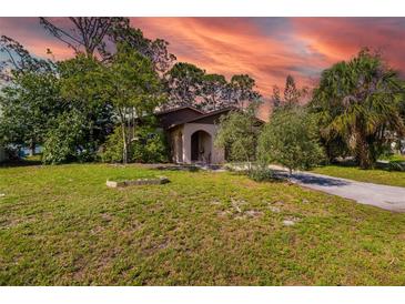 Charming single-story home featuring lush landscaping and a welcoming arched entryway at 1862 Rita St, Sarasota, FL 34231