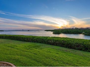 Expansive water view showcasing a beautiful sunset over lush greenery and calm water at 2424 Placida Rd # D102, Englewood, FL 34224