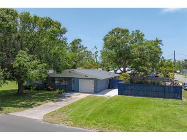 Charming single-story home with a well-maintained lawn, blue fence, and mature trees at 304 34Th W St, Bradenton, FL 34205