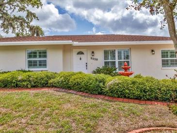 Charming single-story home featuring a well-manicured lawn and mature landscaping at 3328 Kingswood Dr, Sarasota, FL 34232