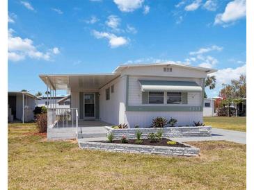 Charming single-story home featuring a covered porch, well-maintained lawn, and attractive landscaping at 5213 Bel Air Ave, Sarasota, FL 34234